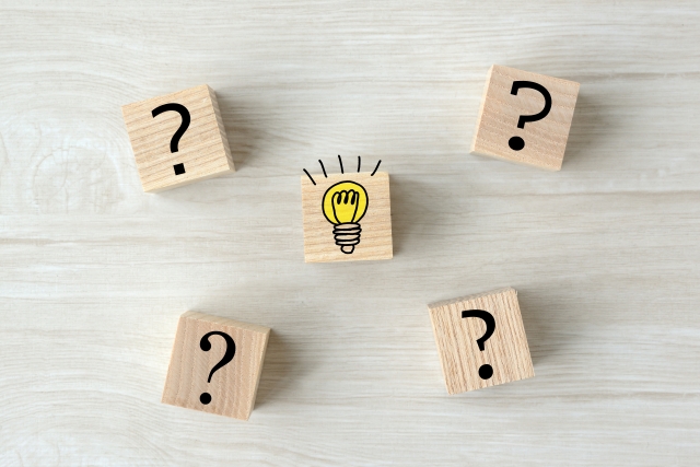 電球のイラストを中心にクエスチョンマークの木製ブロックが並ぶイメージ