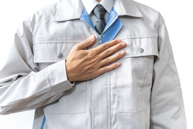 作業服を着た人物が胸に手を当てている誠実・信頼のイメージ